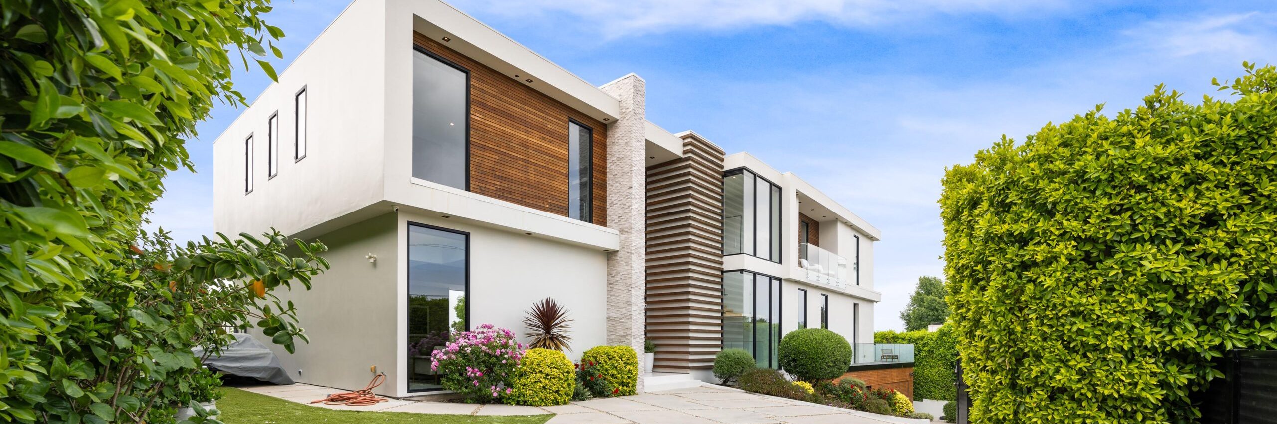 A Driveway of a contemporary house with a garden area